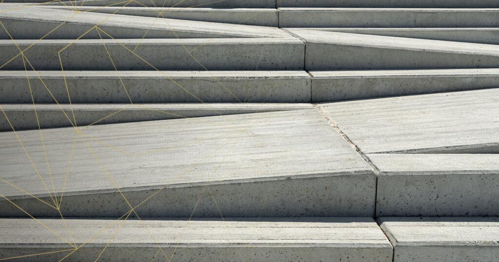 Eine Aufnahme von mehreren Betonstufen, die in einem geometrischen Muster angeordnet sind. Die Stufen sind in verschiedenen Winkeln angeordnet, was einen interessanten visuellen Effekt erzeugt.